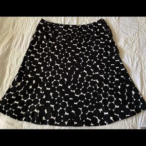 Cool black polka-dot skirt. Angled waist band with 4 black buttons.